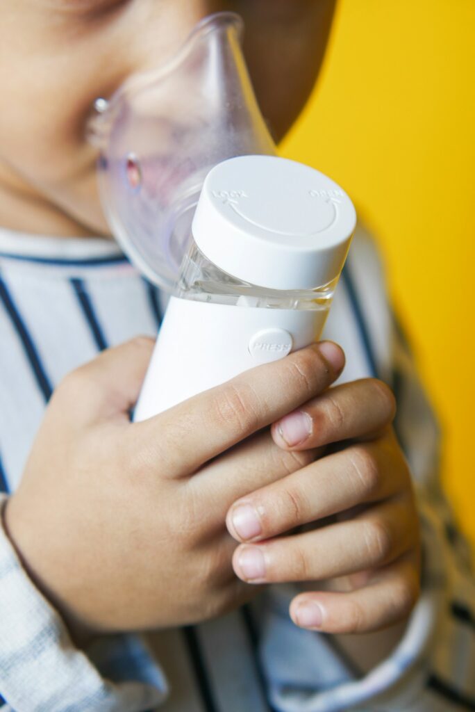 child girl using a nebulizer close up